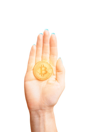 One glowing gold bitcoin on female palm hand on a white background, symbol of virtual money.の写真素材
