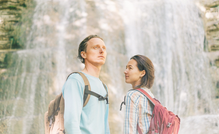 Traveler backpacker young couple standing in front of waterfall in summer outdoor.の写真素材