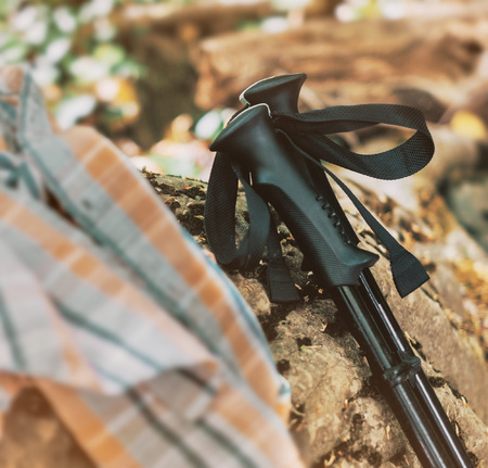 Pair of hiking poles on stone outdoor, close-up. Travel and trekking equipment.