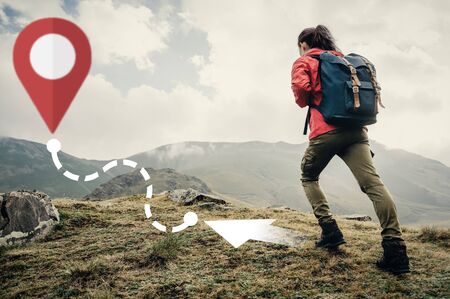 Hiker backpacker young woman going up on mountain to route with location GPS pin outdoor. Navigation...