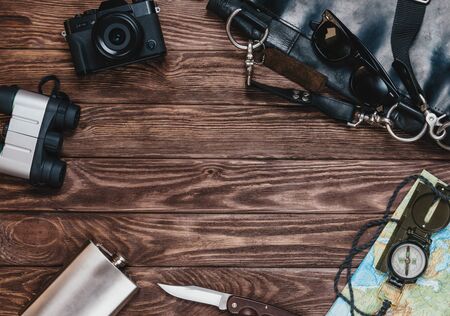 Equipment for journey and tourism on a wooden background, top view. Space for text in center of image.の写真素材