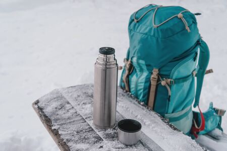 Hiking equipment: backpack and thermos in winter outdoorの写真素材