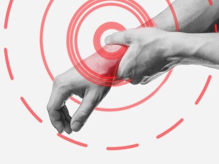 Carpal syndrome. Acute pain in a male wrist. Man holding his hand. Monochrome image, isolated on a white background. Pain area of red color.の写真素材