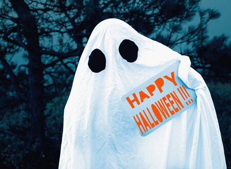 White ghost holding Halloween poster in the night forest