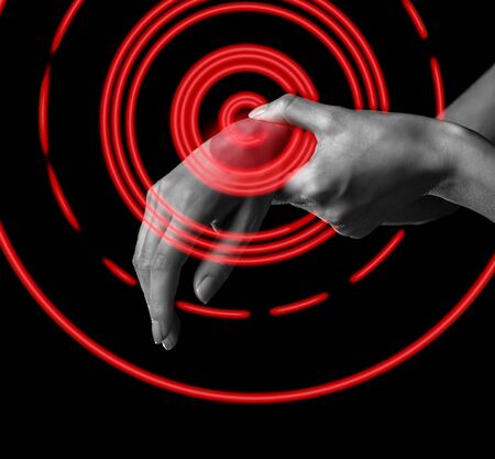 Pain in female wrist. Woman holds her hand, pain area of red colorの写真素材