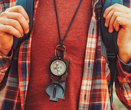 Traveler young man with backpack and compass walking in forest. Close-upの写真素材