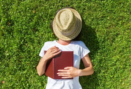 Girl sleep on the Field with bookの写真素材