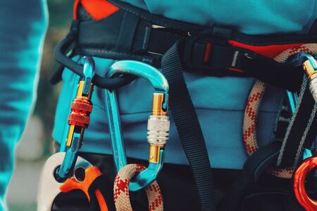 Close-up detail of rock climber wearing safety harness and climbing equipment outdoorの写真素材
