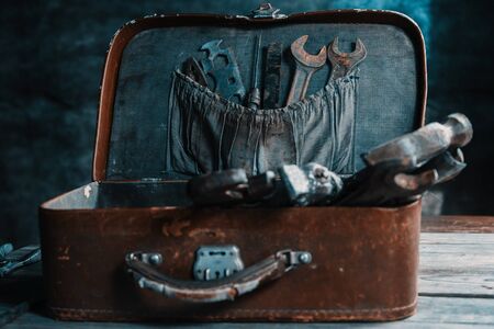 Set of old working tools in vintage suitcase on a wooden table, no peopleの写真素材