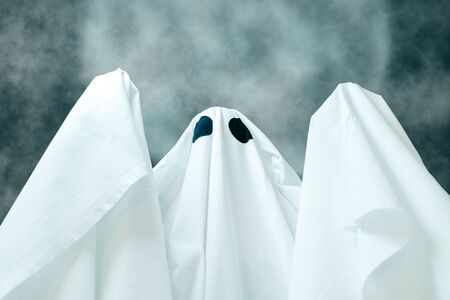 Spooky white ghost with black eyes on background of full moon Halloween night.の写真素材