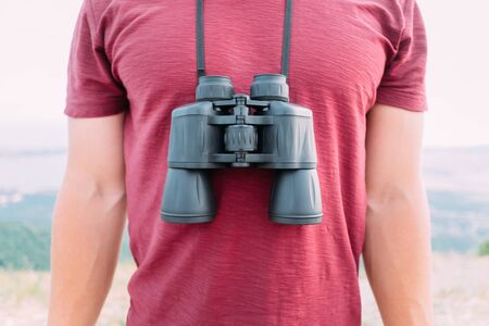Unrecognizable man standing with binoculars in nature outdoor, front view.の写真素材