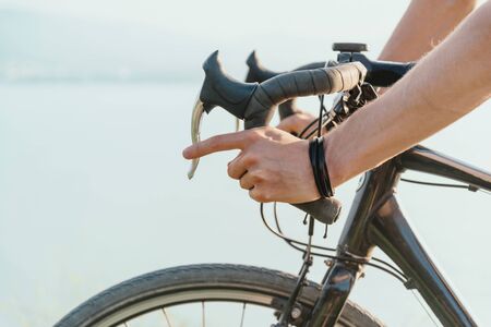 Male hands on a steering wheel with brakes, side view, close-up.の写真素材
