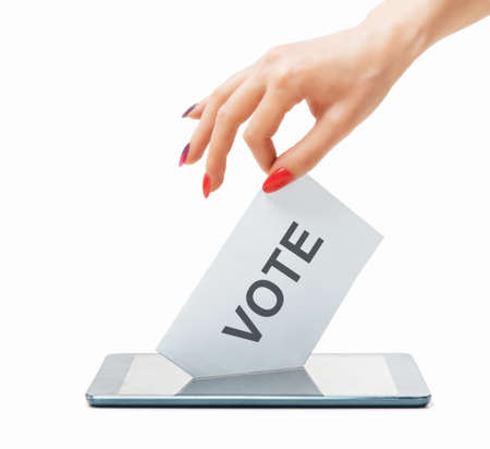 Female hand putting a ballot into a smartphone on a white background. Elections. Concept of remote online voting.の写真素材