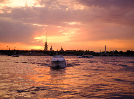 Saint-Petersburg, Russia, 03 September 2020: A tourist boat sails along the Neva River at sunset, with the Peter and Paul Fortress in the background.のeditorial素材