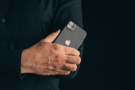 Gelendzhik, Russia, 24 March 2021: Successful businessman folded his arms cross to cross on his chest, holding iphone 11.のeditorial素材