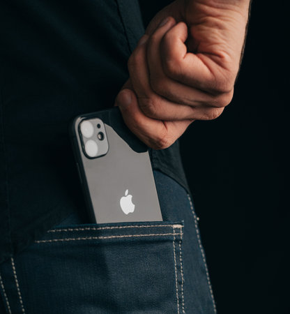 Gelendzhik, Russia, 24 March 2021: The man get out an iPhone 11 out of his pocket. Close-up of the Apple logo and a phone camera.のeditorial素材