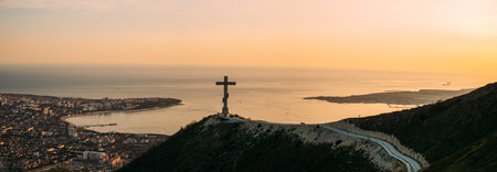 Gelendzhik, Russia, 03 May 2021: Orthodox cross on Markotkh ridge on background of Gelendzhik Bay during sunset.のeditorial素材