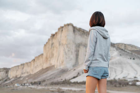 Woman traveler stands near the White rock Ak-Kaya, Crimea.