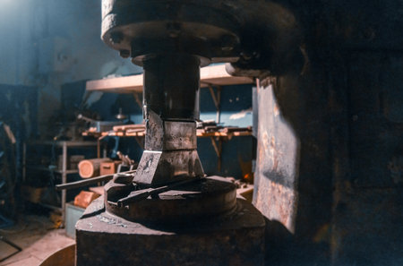 General view of an old percussion machine for forging various metals in a working blacksmith shop.