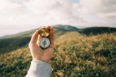 Vintage compass in hands in the mountains.の写真素材