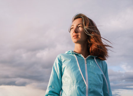 Portrait of a young woman with fluttering hair during the sunset.の写真素材