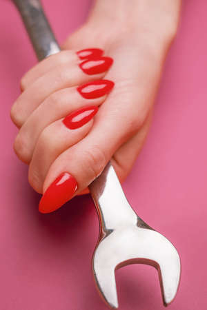 Female hand holding a steel wrench .の写真素材