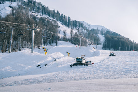 Snowcat ratrack with snowplow snow grooming machine preparing ski slope piste hillalpine skiing winter resort Rosa Khutor.のeditorial素材