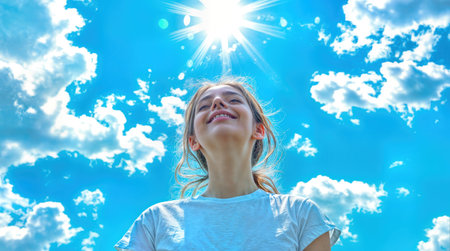 Young woman with radiant smile enjoys sunshine and fresh air on bright summer day. Natural outdoor portrait under blue sky with white clouds happiness, freedom, mindfulness positive wellbeing vibes. Ai generatedの素材