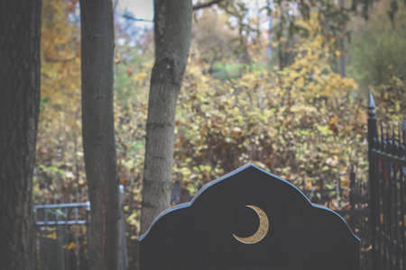 Old islamic cemetery, funeral and burial of muslim. A grave with a stone with crescent moon. Black gravestoneの写真素材