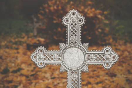 Creepy frosted vintage orthodox cross in the old autumn cemeteryの写真素材