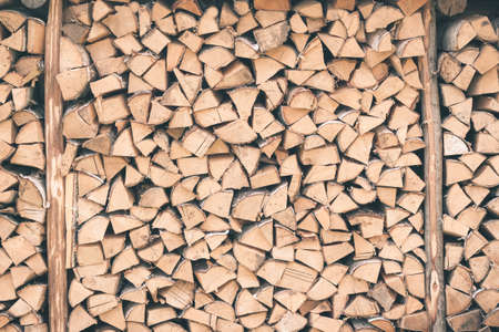Logs of firewood . Fuel for stove heating. Country life. Wooden firewood stacked wall. Natural wood background. Firewood stacked in several rowsの写真素材