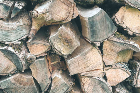 Old Firewood or fuelwood stacked by a wall. Texture woodpileの写真素材