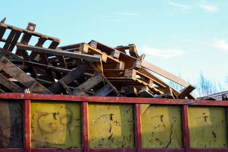 Garbage removal. Pile of wooden pallet waste on background blue skyの写真素材