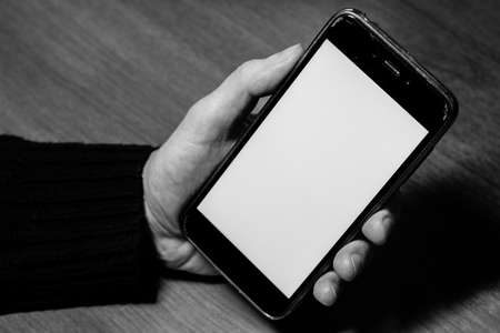 Empty, blank, white screen smartphone with copy space for design or text. Gadget in hand close upのeditorial素材