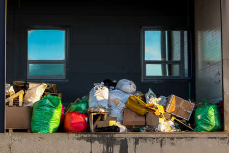 Packaged waste for landfilling. Garbage bags and boxes on the loading dock. Waste removal.の写真素材