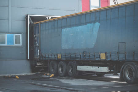 Trucks while loading in a big distribution warehouse. Import export business logistic and transportationの写真素材