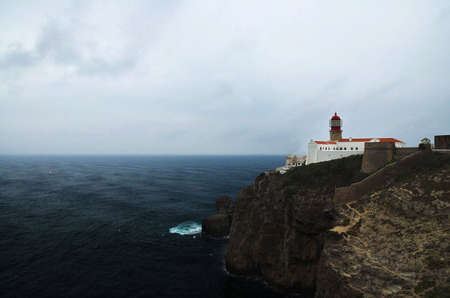 Lighthouse and ruins on a capeの写真素材