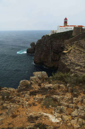 Lighthouse and ruins on a capeの写真素材