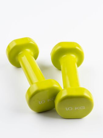 Vertical image of two small green dumbbells together from one kilo on white backgroundの写真素材