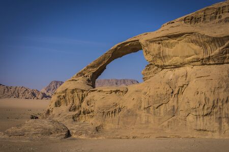 Image of a rocky desert with a a mountain with a big holeの写真素材