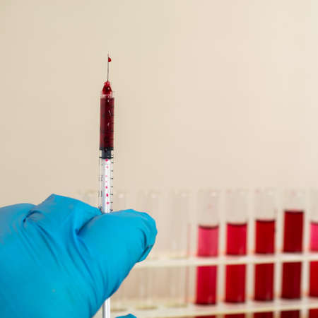 a syringe with a needle and blood or other red liquid