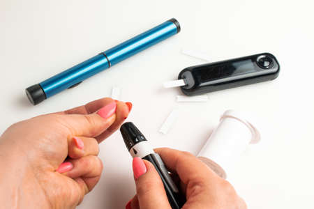 Glucometer. Woman checks blood sugar level for diabetes, insulin levelsの写真素材