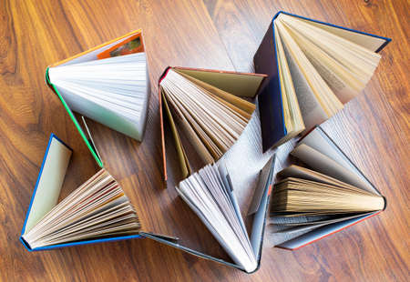 Books stack on wooden table, top view flat lay. Reading, learning, literature concept