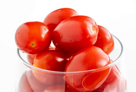 tiny red tomatoes on a white potの写真素材