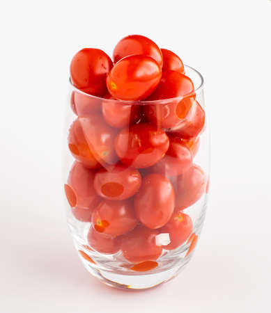 tiny red tomatoes on a white potの写真素材