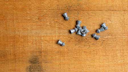 lead bullets on the background of brown boards. lead shot for air rifle. air rifle missiles. air...