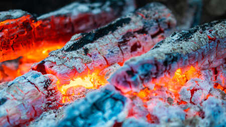 wood is on fire. glowing coals and wood. wood ash. A dying out fire. wallpaper.