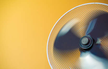 working electric fan, windmill on the background of a yellow wallの写真素材
