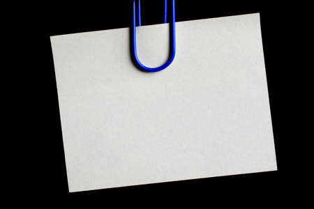 white blank note pinned to a black notice board with a paper clip.の写真素材
