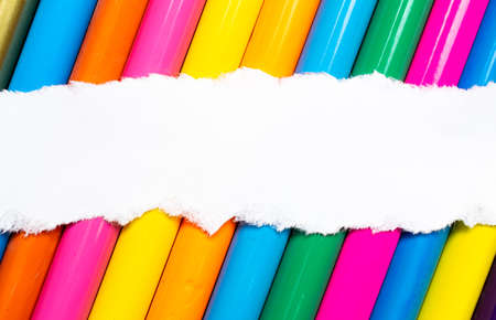 A sheet of white paper on a background of colored pencils. Label for individual text.